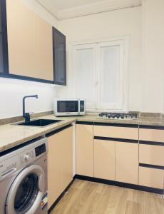 Elegant Downtown Escape في القاهرة: مطبخ مع غسالة ملابس وميكروويف