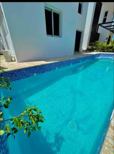 a swimming pool in front of a house at Villa Labuena in Punta Cana