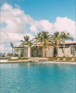 a house with palm trees in front of a swimming pool at Villa Labuena in Punta Cana