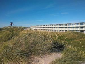 a building on top of a grassy hill next to a building at 4 star holiday home in Blokhus-By Traum in Blokhus