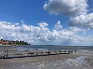 a pier on a beach with a cloudy sky at 6 person holiday home on a holiday park in Hejls in Hejls