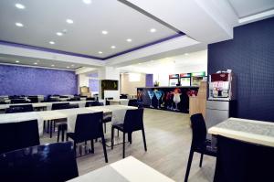 un ristorante con tavoli, sedie e frigorifero di Babylonia Resort a Costinesti