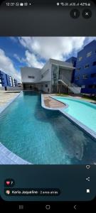 a picture of a swimming pool in front of a building at Impérium residence clube in João Pessoa