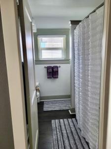 a bathroom with a shower with a window and purple towels at Cottage on Durango in Tacoma +9 photos