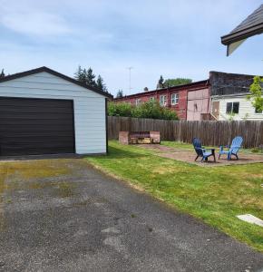 a garage with two chairs and a table in a yard at Cottage on Durango in Tacoma