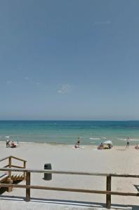 a group of people on a beach near the ocean at Oasis house in Arenales del Sol