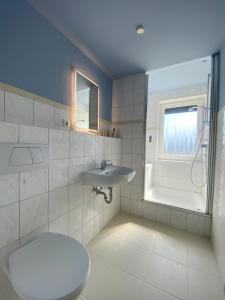 a bathroom with a toilet and a sink and a window at Küstenbutze Büsum in Büsum +53 photos