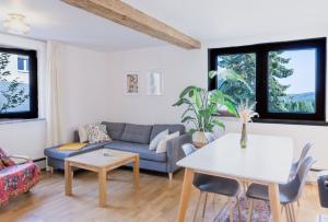 a living room with a couch and a table at Naturblick Apartment - Modernes 3-Zimmer mit Privatparkplatz in Neustadt bei Coburg