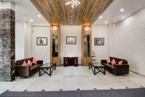 a lobby with two couches and a table at Collection O Rajdhani Hotel in Pune