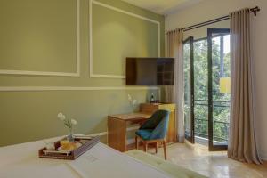 a room with a bed and a desk and a window at Roso Guest House in Mexico City