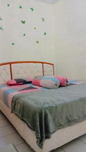 a bed with pillows on it in a bedroom at Villa Highland 9O Berastagi View in Berastagi +9 photos