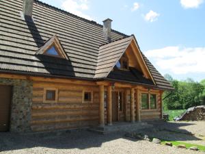 una cabaña de madera con techo de gambrel en Noclegi Pod Małym Królem en Ustrzyki Dolne