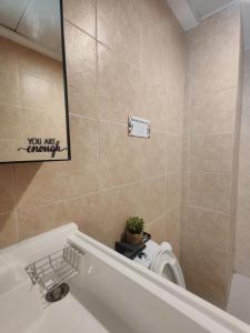 a bathroom with a toilet and a sink and a tub at Fyangz Mini Karaoke Condo Staycation in Minglanilla