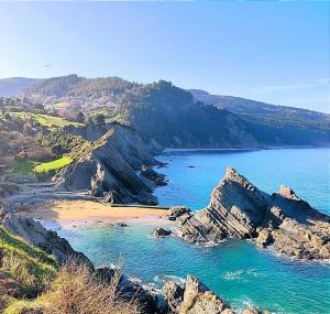Una vista de una playa con rocas y el océano. en Central Park, en Bermeo