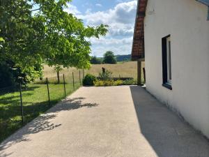 a walkway next to a white building with a window at Maison de campagne 6 pers avec chemins de randonnée et station thermale à proximité - FR-1-589-631 in Montmotier