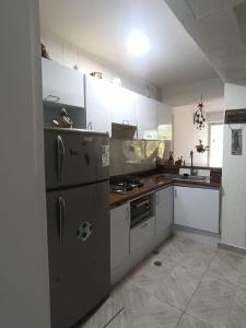 eine Küche mit weißen Schränken und einem Edelstahlkühlschrank in der Unterkunft Apartment in Lechería, Beach, Marina, Shopping in El Morto de Barcelona