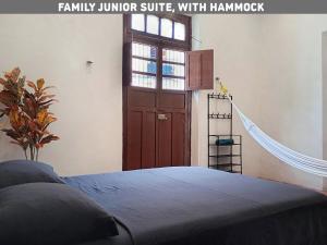 a bedroom with a wooden door and a bed at Villa con piscina para 6 personas en camas y 2 Hamacas Ado 69 in Mérida +40 photos