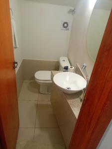 a bathroom with a white toilet and a sink at Lar de charme e tranquilidade em montes Claros in Montes Claros