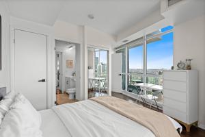 a bedroom with a bed and a view of a city at Apartment with Amazing Views, pool and free parking in Toronto
