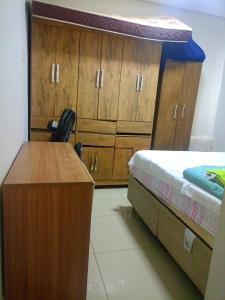 a bedroom with a bed and a desk and cabinets at Lar de charme e tranquilidade em montes Claros in Montes Claros