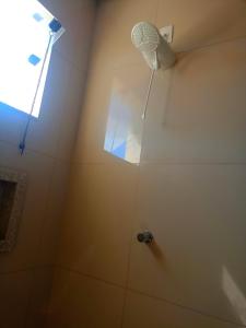 a bathroom with a shower with a fan on the wall at Lar de charme e tranquilidade em montes Claros in Montes Claros +7 photos
