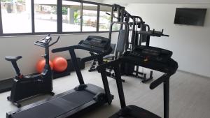 un gimnasio con 3 bicicletas estáticas y TV en Flat Conselheiro Aguiar 1503, en Recife