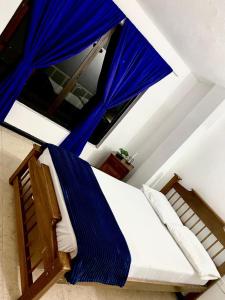 a bed with a blue canopy in a room at Hotel Galería Plaza in Santa Bárbara