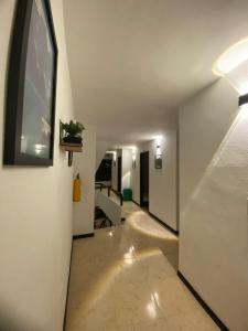 a long hallway with a white wall and a window at Hotel Galería Plaza in Santa Bárbara