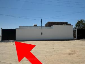 a red arrow in front of a white building at La Casita in Puerto Peñasco