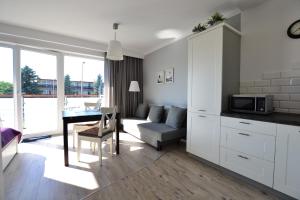 a kitchen and living room with a table and a couch at Darłówko Apartament Morski in Darłówko