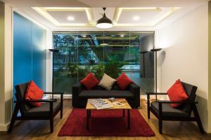 a living room with a couch and two chairs at Super Townhouse MG Road,Bangalore in Bengaluru