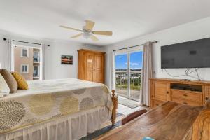 a bedroom with a bed and a flat screen tv at Ocean House 1806 in Gulf Shores