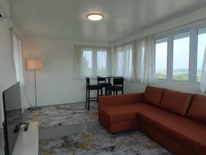 a living room with a couch and a table with chairs at Panoramic View & Spacious with Swimming Pool Aza Sunset Villa 1 in Langkawi Intl
