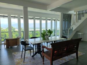 a dining room with a table and chairs and windows at Aza Sunset Villa in Langkawi Intl