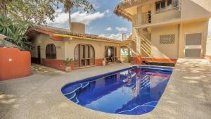 a swimming pool in front of a house at Las Olas Litibu Bungalow By The Sea in Higuera Blanca