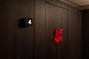 een rode strik op een deur met het getal vier bij Erika's Apart Hotel in Pristina
