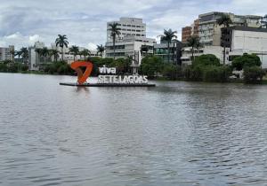 a sign in the middle of a body of water at hotel no centro in Sete Lagoas +4 photos