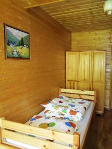 1 dormitorio con 1 cama en una pared de madera en Noclegi Pod Małym Królem en Ustrzyki Dolne