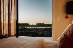 ein Schlafzimmer mit einer Tür zu einem Fenster mit Aussicht in der Unterkunft Big Heart Beach in Ruatapu