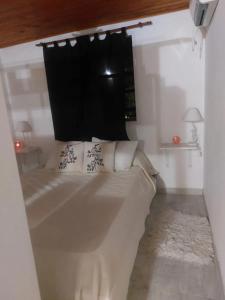 a large white bed in a white room at La casita in San Clemente del Tuyú