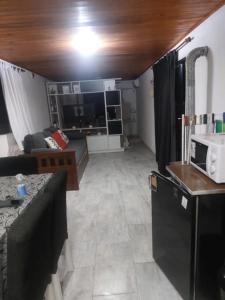a living room with a couch and a microwave at La casita in San Clemente del Tuyú