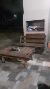 a wooden bench sitting in a room with a fireplace at La casita in San Clemente del Tuyú