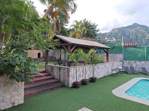 a backyard with a swimming pool and a pavilion at Hotel Tepoztlán in Tepoztlán