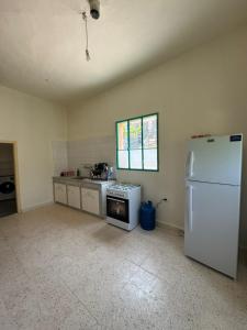 a kitchen with a white refrigerator and a stove at Yassmina Guest House in Maasser El Chouf +12 photos