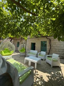 a group of chairs and tables under a tree at Yassmina Guest House in Maasser El Chouf