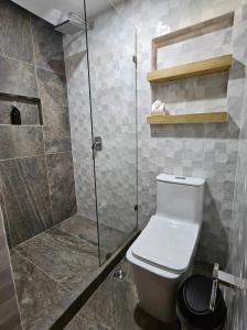 a bathroom with a toilet and a glass shower at Elite Maya Hotel & Spa in Antigua Guatemala +21 photos