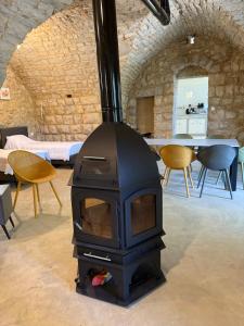 a stove in a room with chairs and a table at Yassmina Guest House in Maasser El Chouf