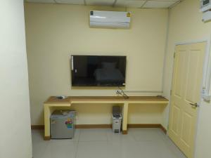 a room with a desk with a television on a wall at UOKResort in Ban Bang Khen (1)