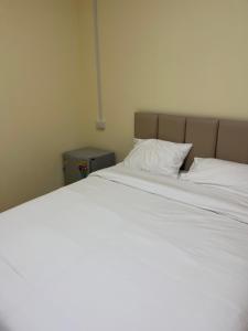 a large bed with white sheets and a pillow at UOKResort in Ban Bang Khen (1) +2 photos