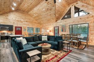 ein Wohnzimmer mit einer blauen Couch und einer Küche in der Unterkunft Brand New Cabin close to PForge and GBurg in Sevierville